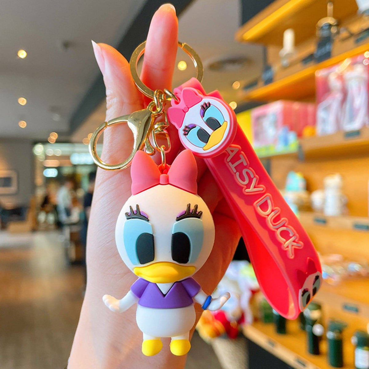 Daisy Duck keychain from Shopping Island featuring a cartoon Daisy Duck figure on a silver keyring.